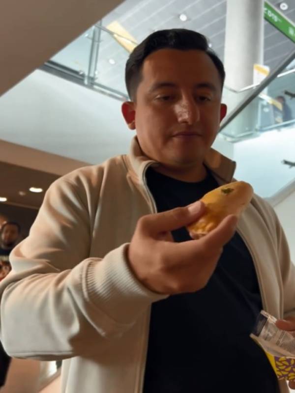 Eduardo Gonzalez esposo de Yessica Carcamo degusta una empanada colombiana