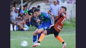 El español Gregori Díaz (i.) protege el balón, ante la marca por detrás de Juan Barahona. Al fondo, observa el DT 