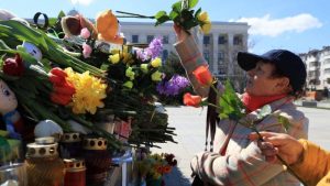 una mujer deja flores como parte del duelo nacional tras masacre en Rusia