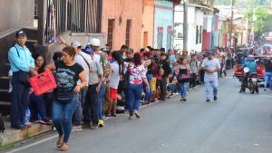 Las personas esperan en una larga fila para recibir el beneficio gubernamental de la tarjeta agrícola, en el Destacamento Militar Número Siete, en Ahuachapán.