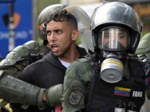 Miembros de la guardia nacional Bolivariana detienen a un hombre durante una protesta