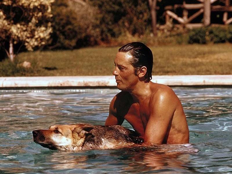 Alain Delon en su juventud, jugando con una mascota