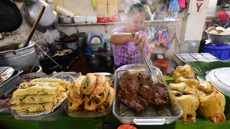 Mujer elaborando comida en el Mercado de San Salvador