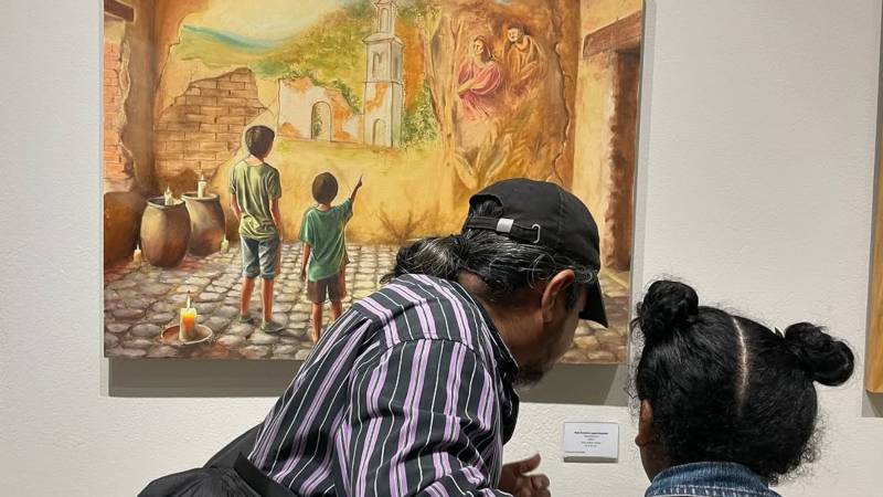 Asistentes a la inauguración de la muestra contemplan la obra 