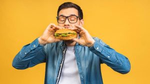 joven comiendo hamburguesa