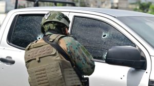 Un oficial militar observa impactos de bala en la camioneta en la que un coronel de las Fuerzas Armadas de Ecuador fue asesinado en Guayaquil, Ecuador, el 14 de febrero de 2025. Un coronel de las Fuerzas Armadas de Ecuador fue asesinado a tiros el viernes cerca de la Penitenciaría del Litoral en Guayaquil (suroeste), en un país sumido en la violencia del narcotráfico, dijo la policía