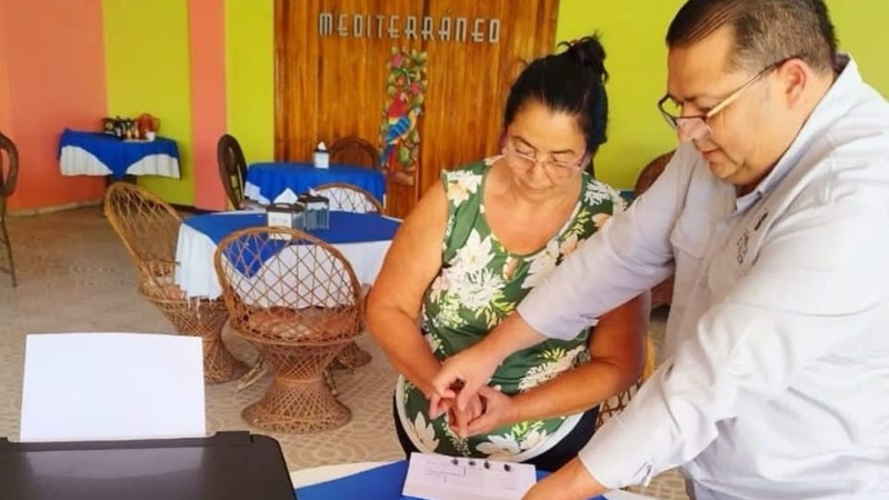 Manuel Bonilla Carrillo atiende a una salvadoreña como empleado de la Embajada del país en Costa Rica. El exempleado de la sede diplomática asegura que nunca tuvo problemas en más de 30 años de servicio. / Foto cortesía