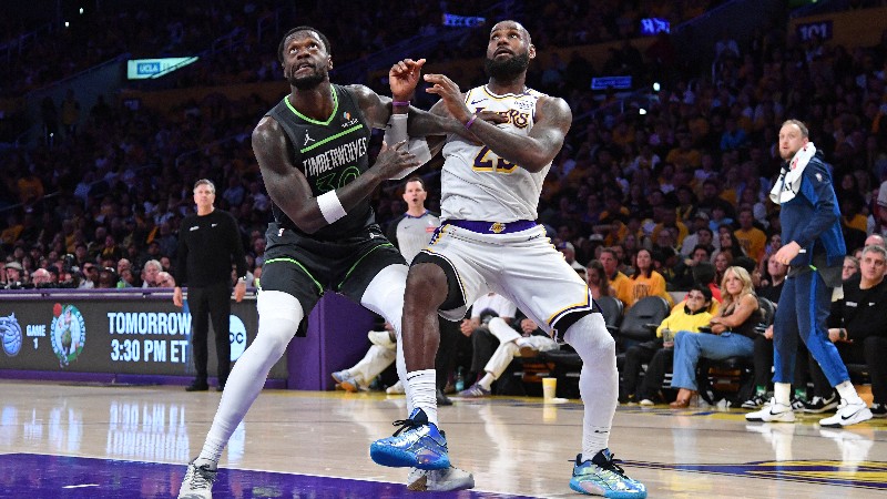 Julius Randle, de los Timberwolves (i.) pelea por el balón con LeBron James, de los Lakers. Foto EDH/AFP.