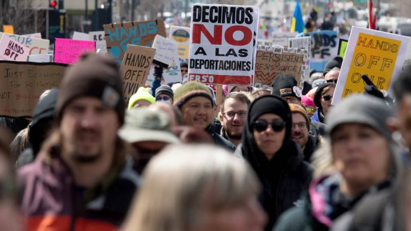 Un manifestante sostiene un cartel que dice 