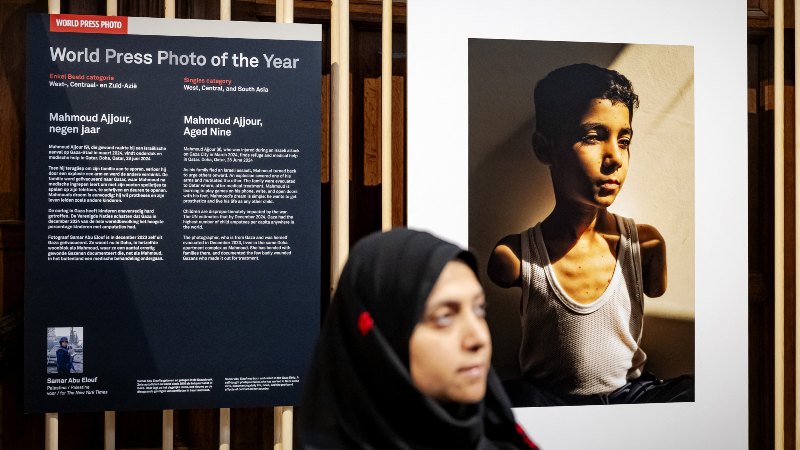 La fotoperiodista palestina Samar Abu Elouf, ganadora del premio World Press Photo de 2025, posa junto a su fotografía ganadora. / 