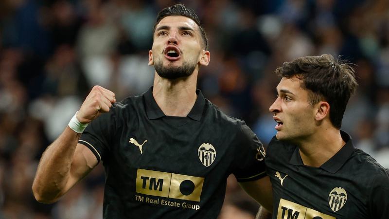 El delantero del Valencia Hugo Duro (d) celebra con su compañero Rafa Mir el segundo gol de su equipo durante el partido de LaLiga entre el Real Madrid y el Valencia disputado este sábado en el estadio Santiago Bernabéu en Madrid. EFE/Chema Moya.