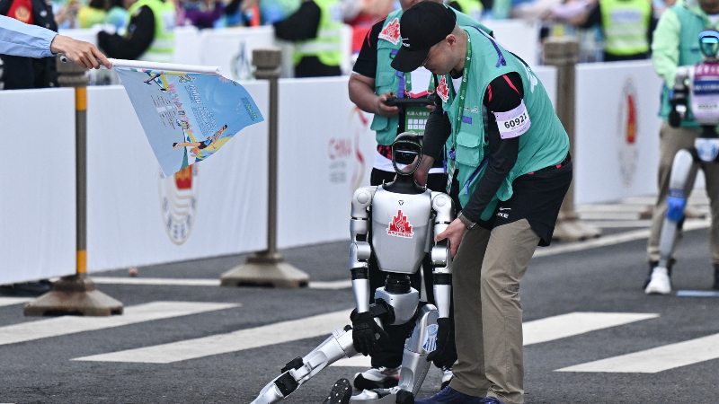 Un robot pierde el control al inicio de la media maratón de robots humanoides