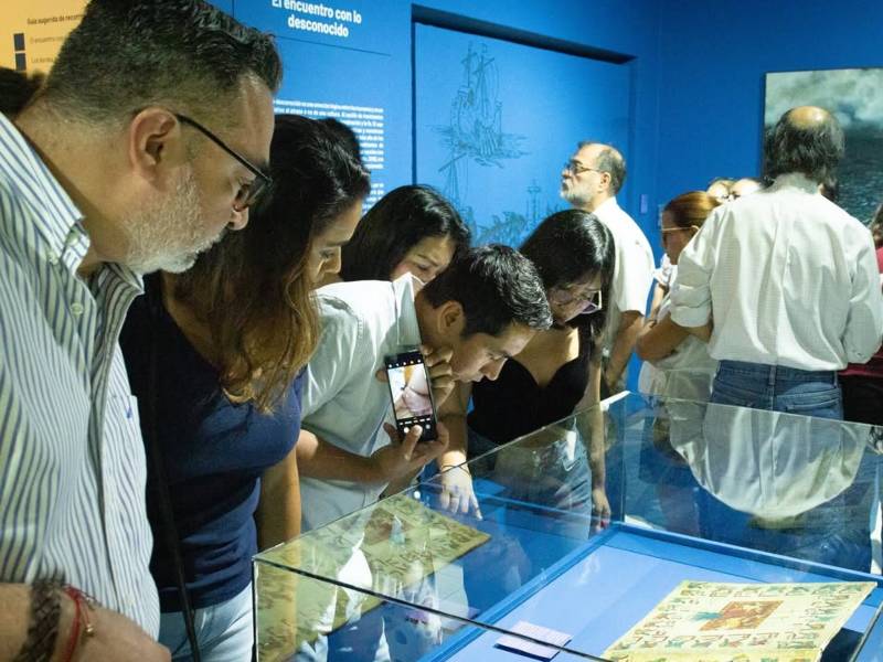 Asistentes a la inauguración contemplando la muestra