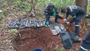 Agentes de la PNC revisan el arsenal que estaba oculto en un barril. Foto / Cortesía @Vi11atoro