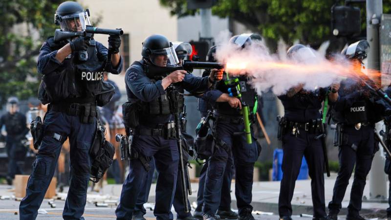 La policía dispara armas no letales contra activistas que se esconden tras una barricada improvisada durante las protestas provocadas por las redadas migratorias en Los Ángeles, California, EE. UU., el 8 de junio de 2025. El presidente estadounidense, Donald Trump, ha desplegado 2.000 efectivos de la Guardia Nacional, a pesar de no haber recibido ninguna solicitud de asistencia adicional del estado de California, tras las multitudinarias protestas contra las redadas migratorias en curso en el área de Los Ángeles durante los últimos días. (Protestas) EFE/EPA/ALLISON DINNER
