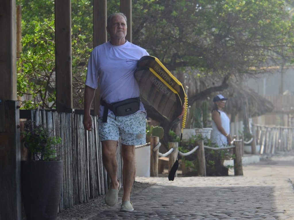 Turista con su tabla en Playa El Tunco, Surf City 1
