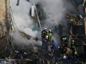 Socorristas trabajan entre los escombros tras el ataque ruso que dejó al menos 18 muertos en Kiev.