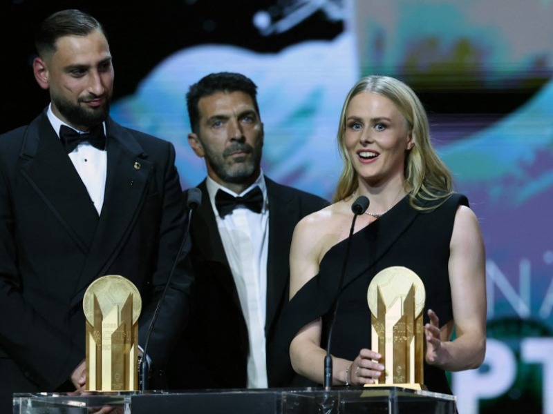 La portera de Inglaterra, Hannah Hampton, habla junto al guardameta de Italia, Gianluigi Donnarumma (izq.), después de que ambos recibieran el Trofeo Yashin a los mejores porteros durante la ceremonia del Balón de Oro 2025 de France Football en el Théâtre du Châtelet de París. En medio, el mítico exguardameta italiano Gianluigi Buffon. / AFP