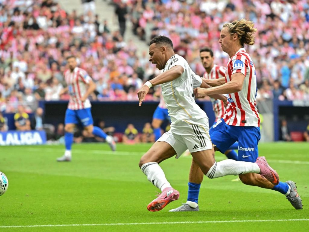 Kylian Mbappé (izq.) del Real Madrid marcado por Marcos Llorente del Atlético de Madrid. Foto AFP