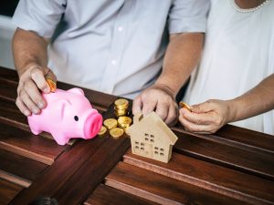 Elderly Couples talking about finance with piggy bank
