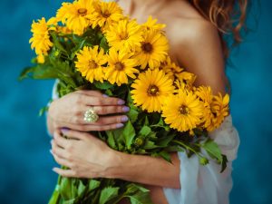 nice and lovely yellow wildflowers in women's hands