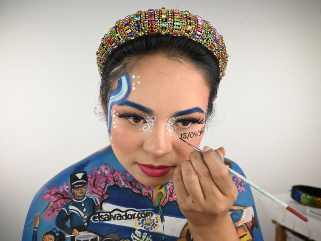 Marcela Peraz colocando la fecha de independencia en su maquillaje