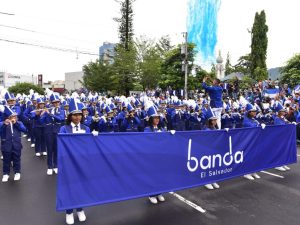 La Banda El Salvador, con más de mil integrantes vestidos de azul y blanco, inunda de música y patriotismo la avenida Juan Pablo II en San Salvador.