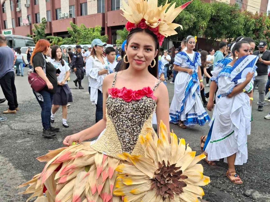 Joven estudiante luce un traje elaborado con tusa y granos de maíz, símbolo de identidad cultural salvadoreña, durante el desfile del 15 de septiembre en San Salvador.