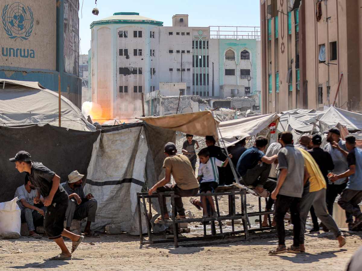 La gente corre mientras estalla una explosión en uno de los edificios de la Universidad Islámica de Gaza en la Ciudad de Gaza .