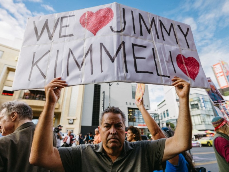 Un hombre sostiene un cartel con la leyenda "Amamos a Jimmy Kimmel" frente al Teatro El Capitán en Hollywood Boulevard, Hollywood, California.