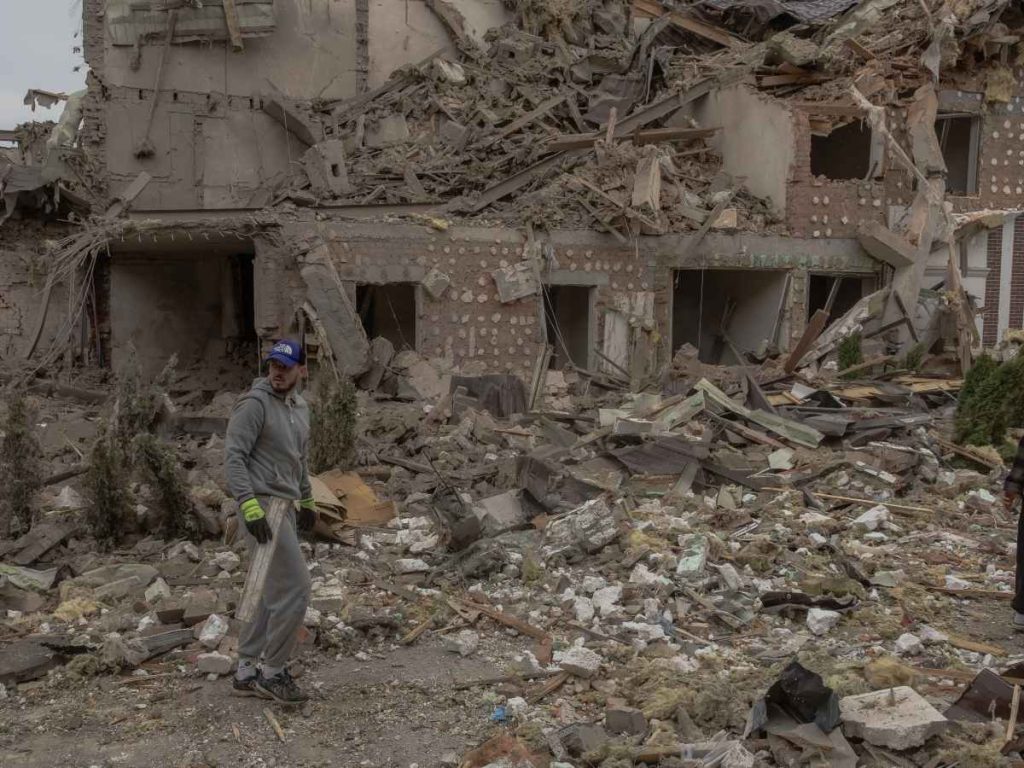 Un hombre camina en el lugar donde se encuentran edificios residenciales gravemente dañados tras un ataque aéreo ruso a las afueras de Kiev