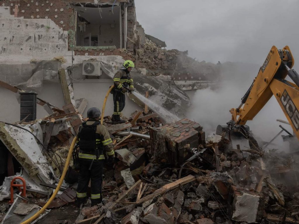 Rescatistas ucranianos trabajan en el lugar donde se encuentran edificios residenciales gravemente dañados tras un ataque aéreo ruso a las afueras de Kiev
