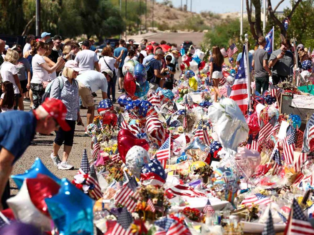 La gente se reúne en un monumento improvisado en honor al activista de derecha y fundador de Turning Point USA, Charlie Kirk, frente a su sede en Phoenix, Arizona