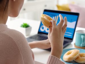 Comer frente a la computadora bajo presión laboral suele llevar a elegir opciones rápidas y menos saludables, un hábito que los expertos vinculan con el estrés y la falta de pausas.