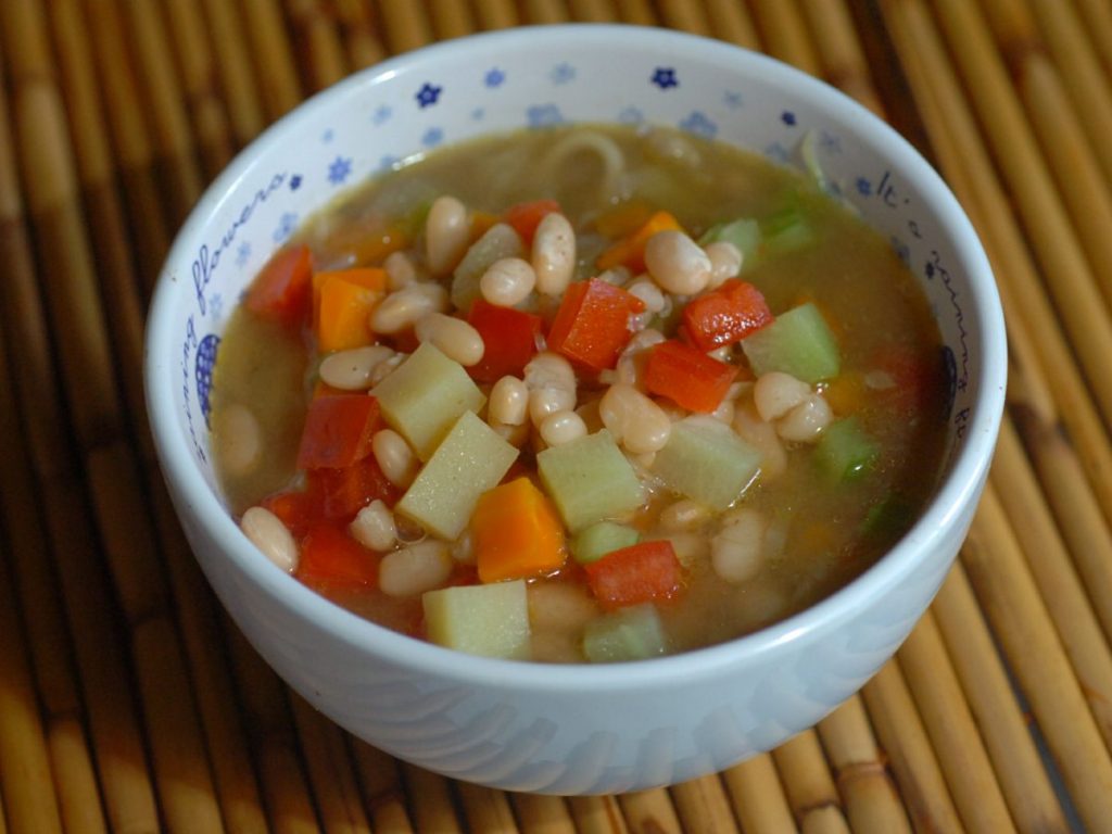Minestrone al estilo salvadoreño, una sopa colorida y ligera que combina frijoles blancos, verduras frescas y hierbas aromáticas en un plato lleno de sabor y frescura.