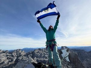 Alfa Karina Arrué ondea la bandera salvadoreña en la cima de Puncak Jaya, uno de los puntos más remotos y altos del planeta insular.