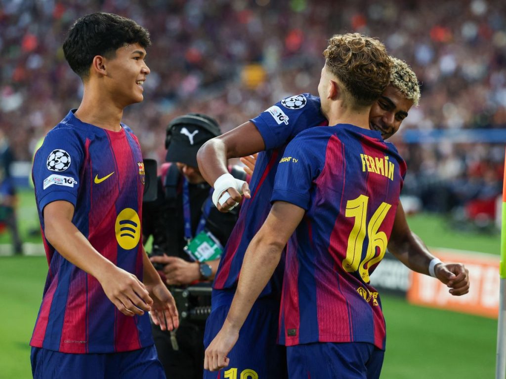 Pedro Fernández (izq.) Lamine Yamal y Fermín López (16) celebran gol del Barcelona ante el Olympiacos en Champions League. Foto AFP