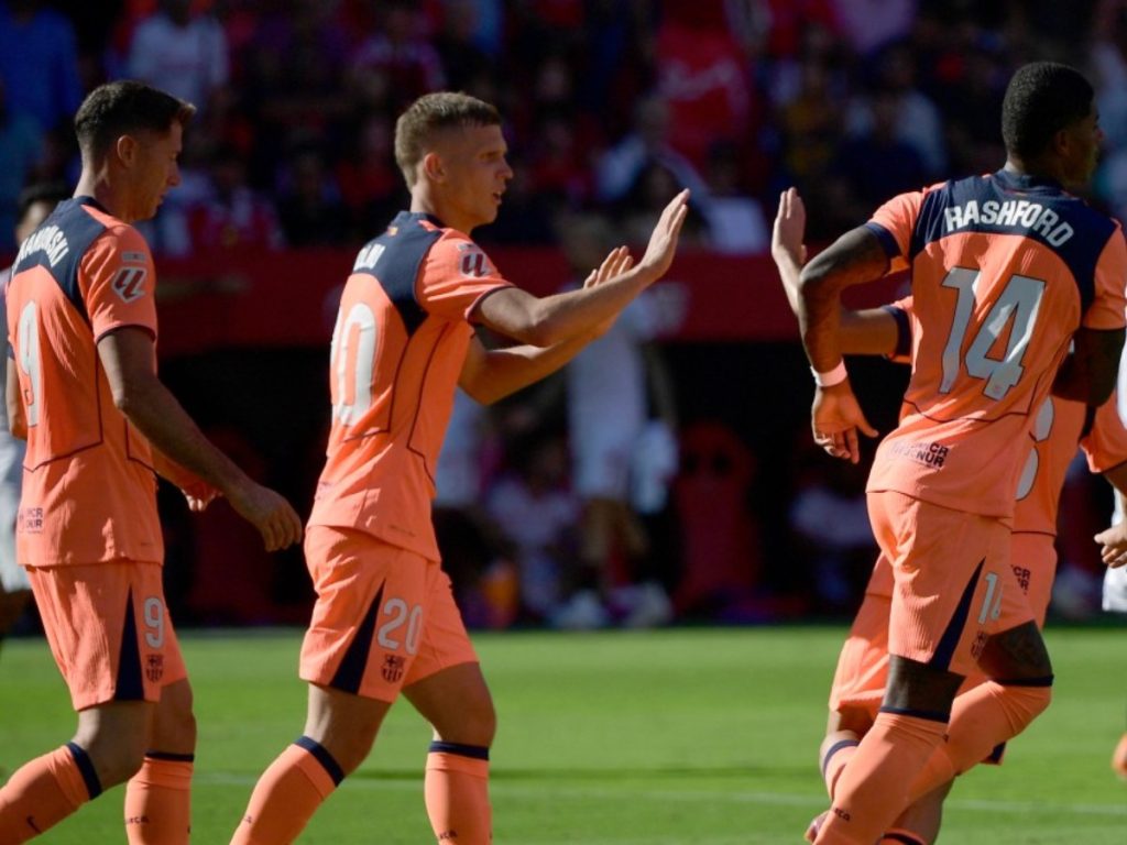 Los jugadores del Barcelona celebran su primer gol, anotado por el delantero inglés Marcus Rashford (#14), durante el partido de la Liga española entre el Sevilla FC y el FC Barcelona, disputado en el estadio Ramón Sánchez-Pizjuán, en Sevilla, el 5 de octubre de 2025. Fotografía/ AFP