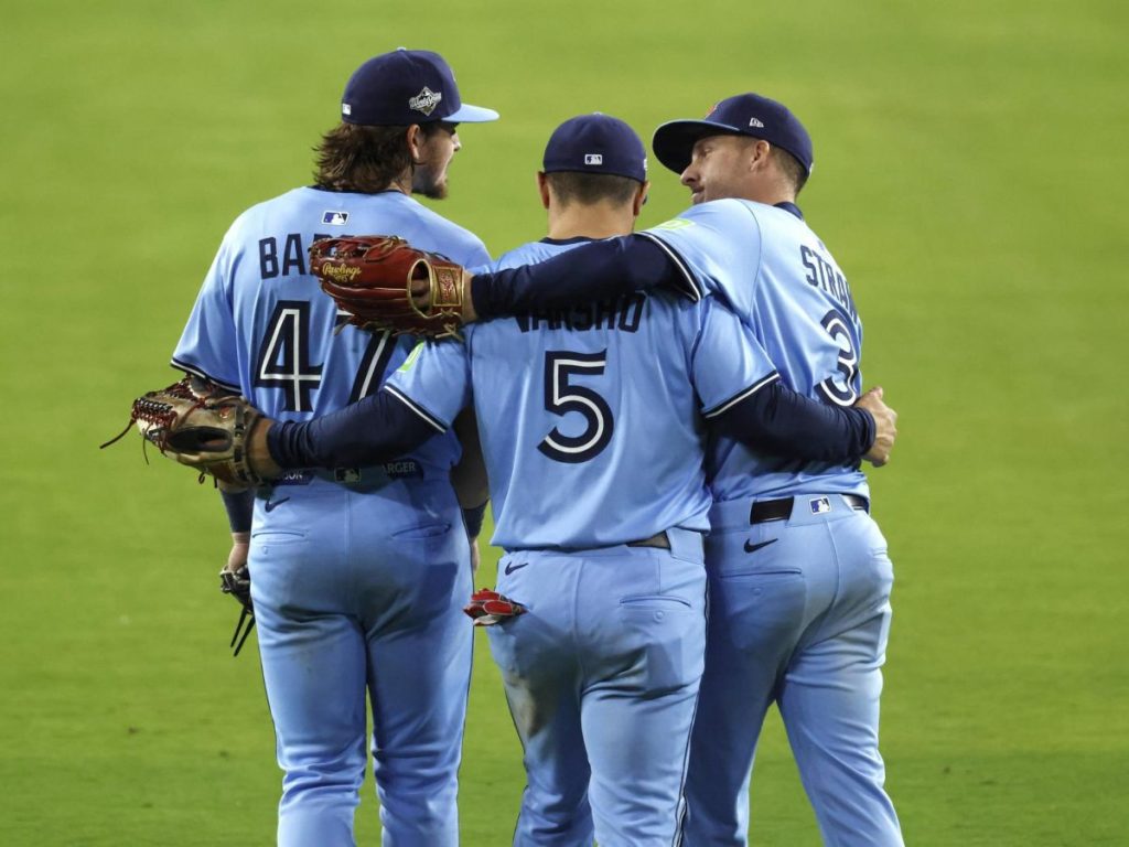 Addison Barger (izq.), Daulton Varsho (Cent.), y  Myles Straw  de los Blue Jays celebran la victoria contra Dodgers. Foto EFE