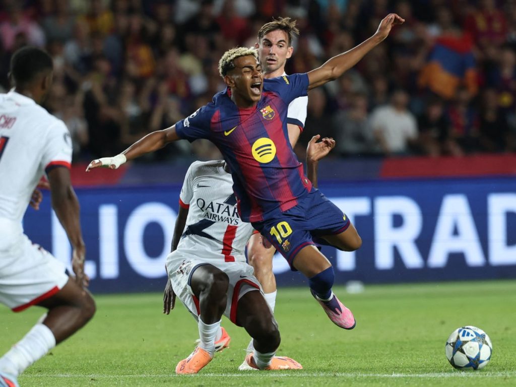 Lamine Yamal (cent.) recibe falta en partido contra el PSG. Foto AFP
