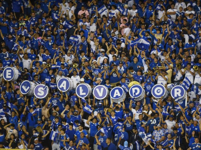 La afición salvadoreña pinta de azul y blanco las gradas, alentando con banderas, tambores y cánticos que resuenan con fuerza en cada rincón del estadio.