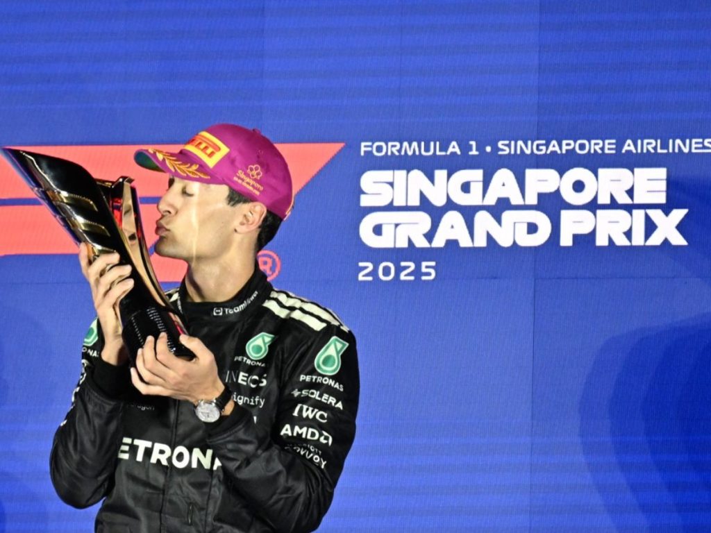 El piloto británico de Mercedes, George Russell, celebra en el podio su primer lugar tras el Gran Premio de Singapur de Fórmula 1, disputado de noche en el circuito urbano de Marina Bay, el 5 de octubre de 2025. Fotografía/ AFP