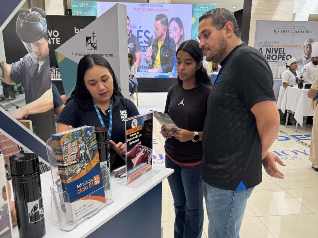 Estudiantes y padres reciben orientación personalizada en el stand de la Universidad Centroamericana José Simeón Cañas (UCA), explorando opciones académicas para el ciclo 01-2026.