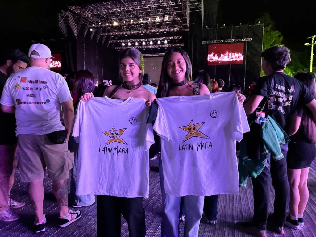 Fans muestran con orgullo las camisetas oficiales de Latin Mafia antes del inicio del concierto en el Estadio Cuscatlán.