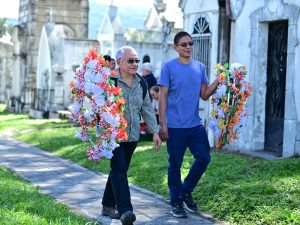 Familias salvadoreñas se reúnen en los cementerios para adornar las tumbas con flores y ofrendas, en una tradición que mezcla fe, amor y memoria. Fotografía/ Archivo