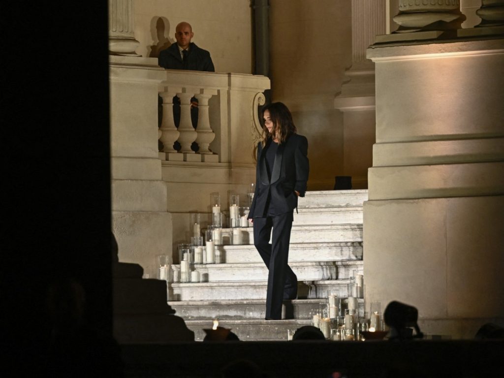 La diseñadora británica Victoria Beckham baja las escaleras para saludar al público al final de la presentación de su colección Prêt-à-porter Primavera-Verano 2025, durante la Semana de la Moda de París, el 27 de septiembre de 2024. Foto/ Archivo AFP