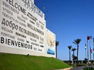 Un mural de bienvenida y Banderas de los países participantes en la cumbre por la paz en Gaza, impulsada por Estados Unidos, ondean en la ciudad turística egipcia de Sharm el Sheij, a orillas del mar Rojo, el 12 de octubre de 2025. Foto/ AFP
