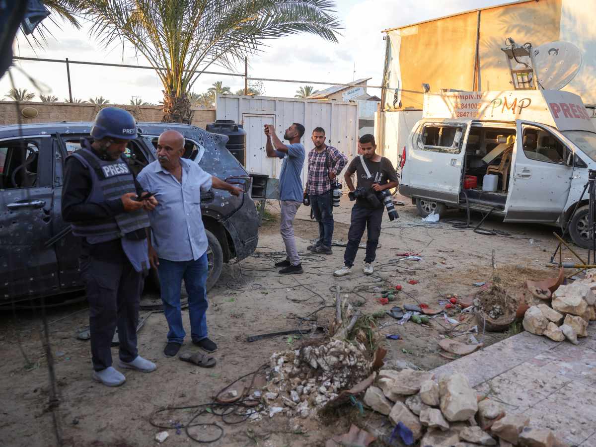 Civiles y periodistas inspeccionan una vivienda destruida en Al-Zawayda, Gaza, tras un ataque israelí que dejó al menos dos muertos, incluido un periodista.