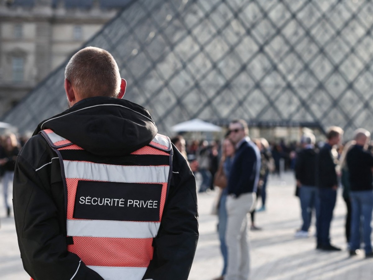 Un guardia de seguridad se encuentra frente a la Pirámide del Louvre, diseñada por el arquitecto chino-estadounidense Ieoh Ming Pei, con el Museo del Louvre al fondo, en París, el 22 de octubre de 2025. Fotografía/ AFP