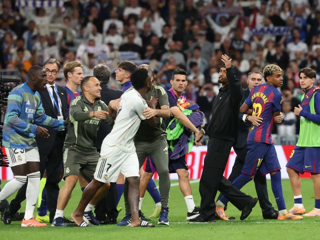 El delantero brasileño #07 del Real Madrid Vinicius Junior (C) discute con el delantero brasileño #11 del Barcelona Raphinha (4R) y el delantero español #10 del Barcelona Lamine Yamal (2R) al final del partido de fútbol de la liga española entre el Real Madrid CF y el FC Barcelona en el estadio Santiago Bernabéu en Madrid el 26 de octubre de 2025